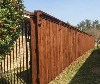 Stained cedar privacy fence with decorative top trim