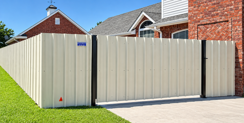 Sheet metal fence installation in Oklahoma City, featuring a beige privacy fence with black posts at a residential property.